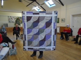 Barbara designed this quilt and made the wavy lines by using a template she made from card, using a limited colour pallet is very effective. Barbara gives many of her quilts to various charities, including Linus.