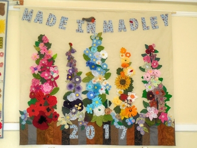 This is the Made in Madley wall hanging constructed in 2017 for the Exhibition.  In September 2021 it was decided to redo it and with help from Sylvia it was deconstructed. The wall hanging was re-made by Evelyn, Davina, Ann, Gill and Valerie and is looking lovely.